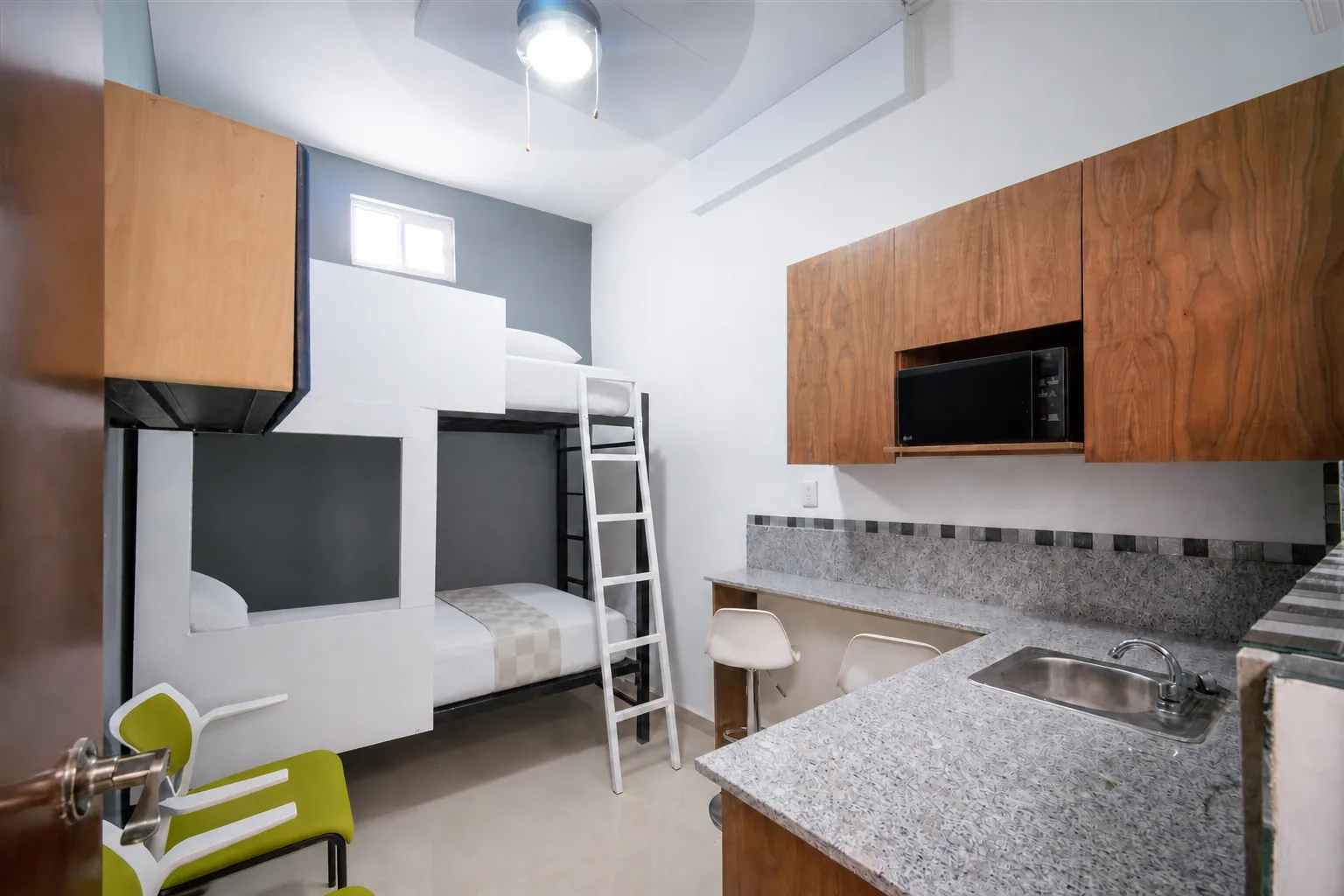 Habitación real para dos personas en el Piso 2, con litera individual y ventilador de techo